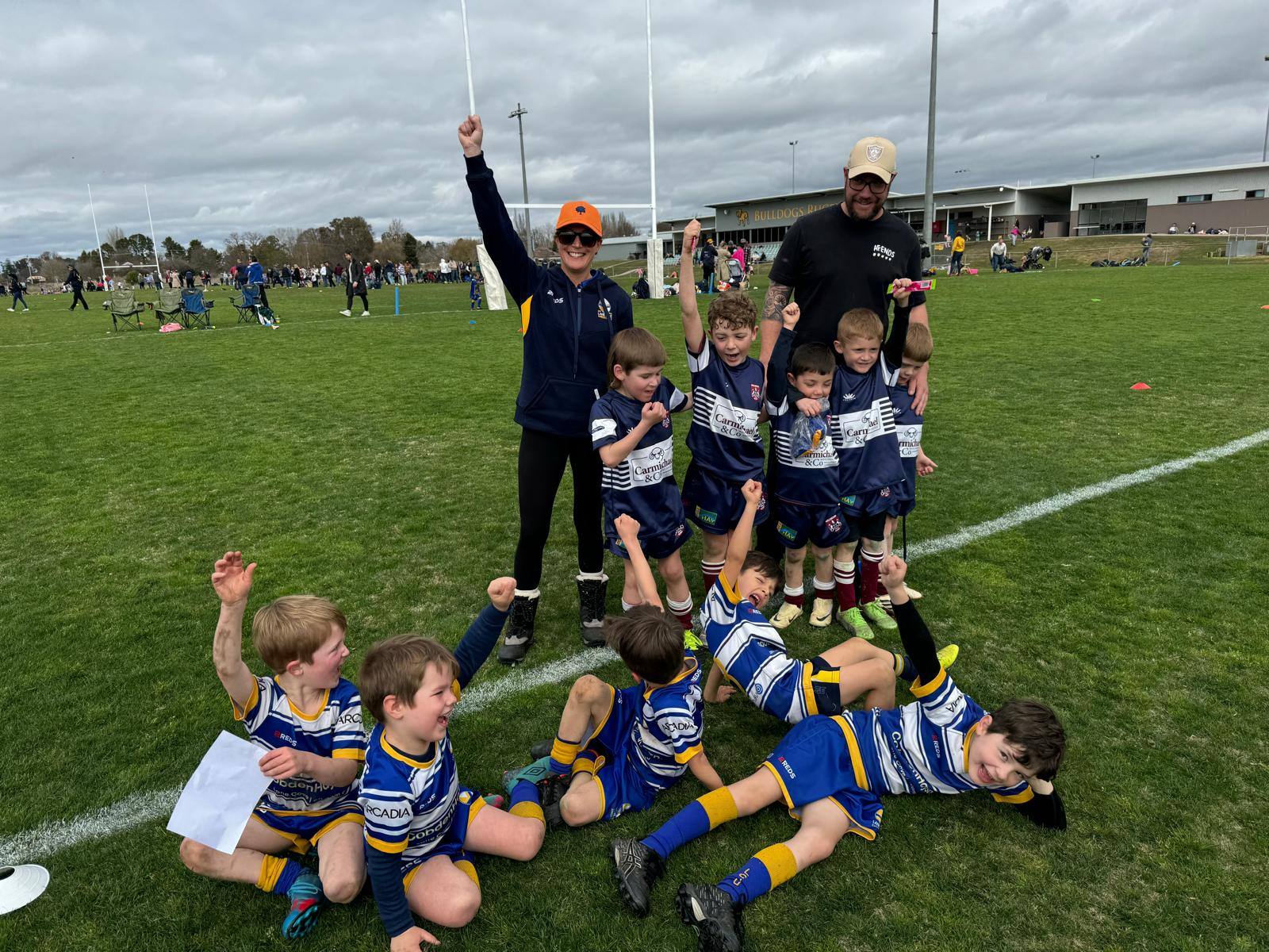 Lane Cove players celebrating with coaches on the field at Bathurst Bulldogs